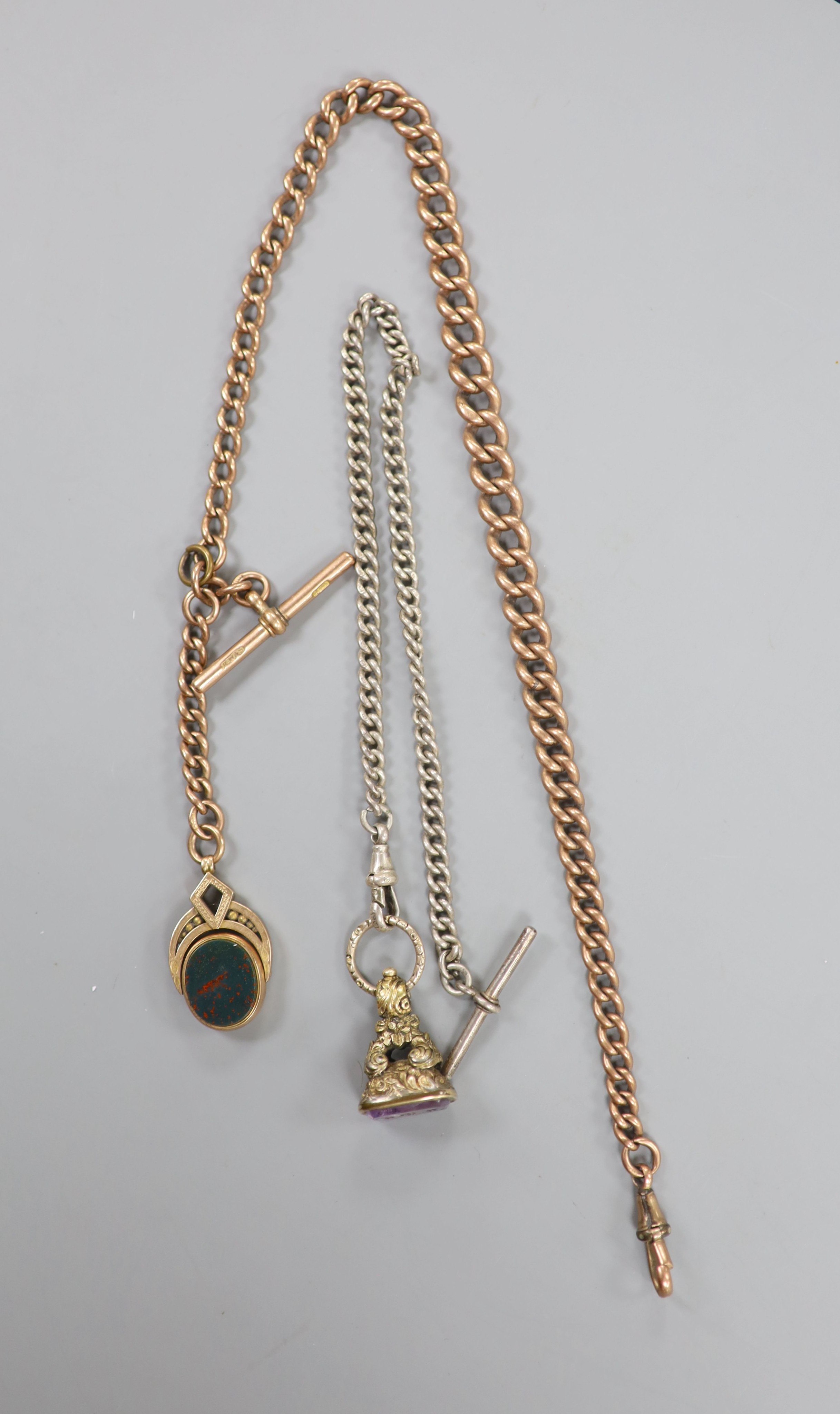 An Edwardian 9ct gold albert, hung with a 9ct gold and chalcedony set swivelling bob seal, albert 38cm, gross weight 49.5 grams, together with a silver albert with gold plated fob seal.